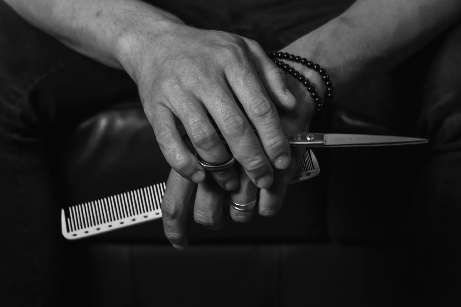 Hände eines professionellen Friseurs mit Schere und Kamm